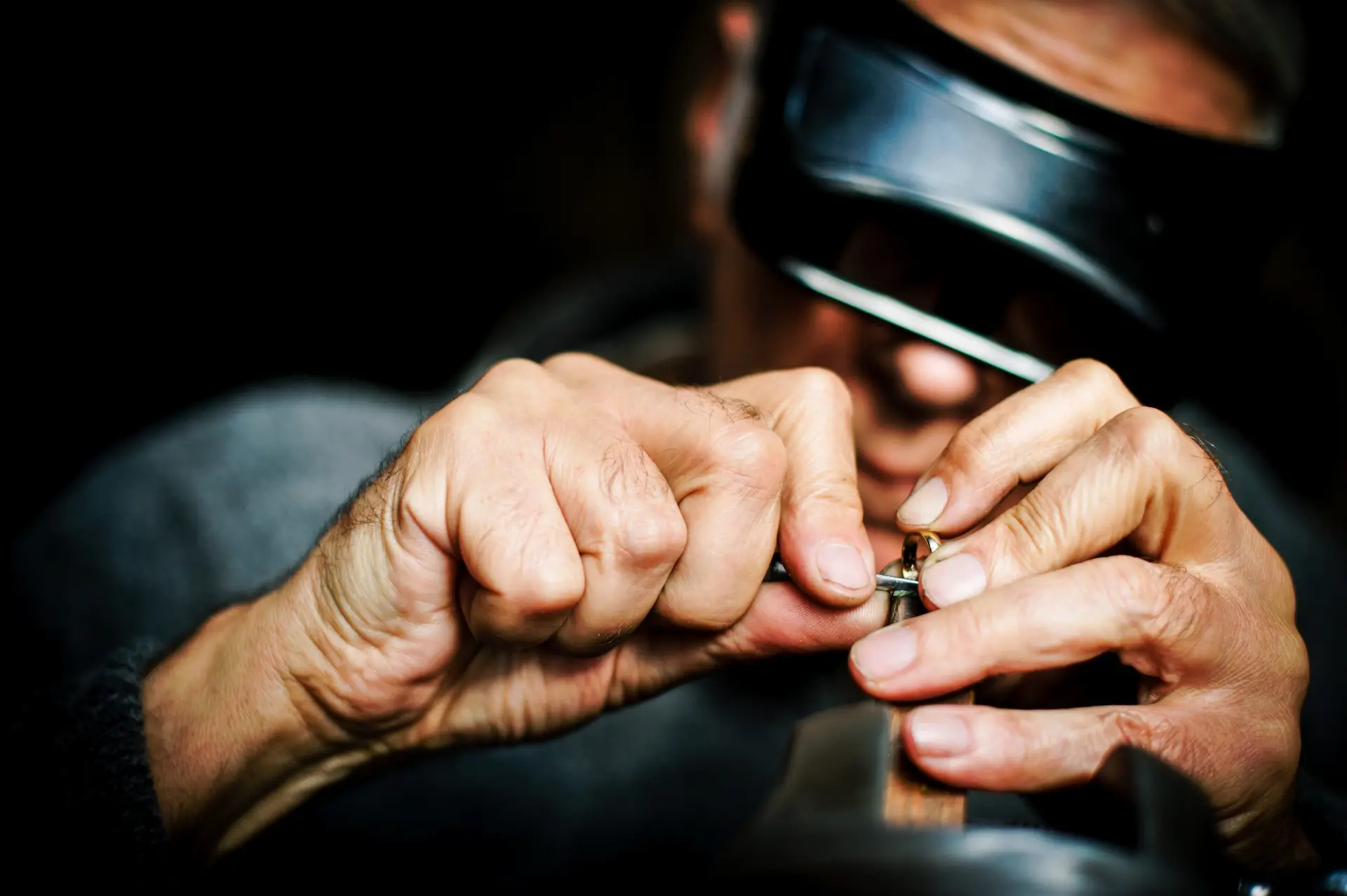 Master jeweler wearing a loupe, handcrafting a custom gold ring at the bench in the Lalo Stylings Los Angeles workshop