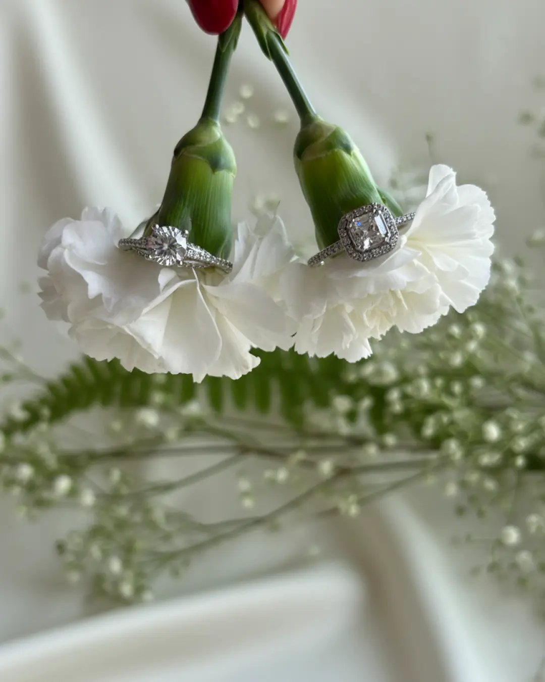 Handcrafted diamond engagement rings custom made in our Los Angeles studio, styled on white carnations