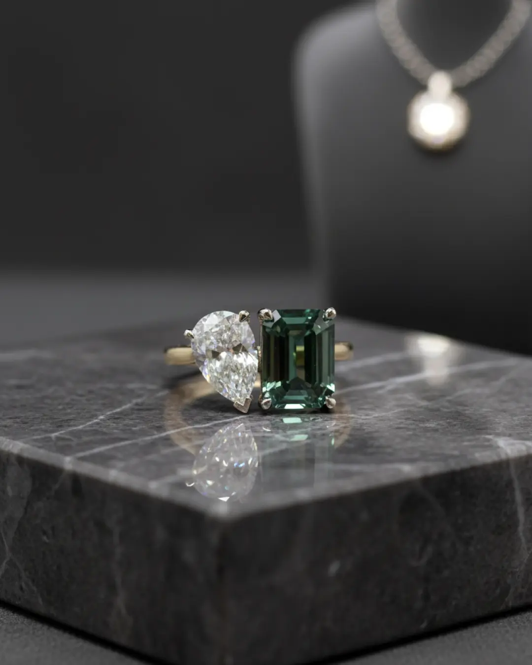Handcrafted toi et moi ring with a pear-cut diamond and emerald-cut green gemstone, custom made in our Los Angeles studio